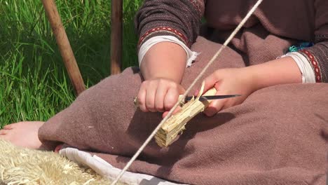 Viking-re-enactment-woman-whittling-wood-to-make-cooking-tool-at-Waterford-Ireland
