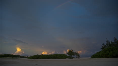 Ein-Friedlicher-Sonnenuntergang-Mit-Einem-Regenbogen-Am-Himmel-An-Einem-Einsamen-Strand-In-Der-Nähe-Von-Cancun,-Mexiko