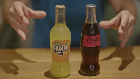 Bartender-placing-bottles-of-Fanta-and-coca-cola-on-counter