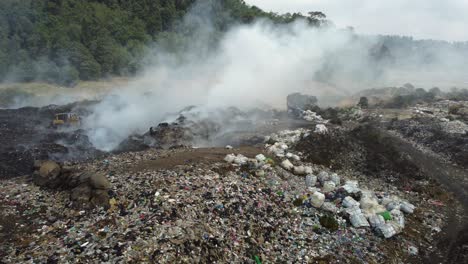Aerial-orbits-burning-garbage-smoke-in-large-landfill-site,-Guatemala