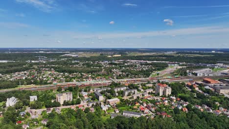 Panoramic-view,-houses-of-a-small-town-stand-near-the-railway-station,-sunny-summer-day