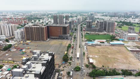 Aerial-drone-camera-moving-forward-from-ring-road-of-Rajkot-city-showing-very-tall-high-rise-buildings