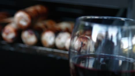 Wine-Glass-Focus-Pull-to-Cooked-BBQ-Sausages