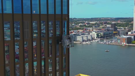 Antena-De-Limpiadores-De-Ventanas-Suspendidos-En-Una-Cuna-Fuera-Del-Hotel-Draken,-Gotemburgo,-Suecia