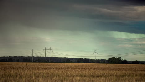 Static-shot-of-rain-cloud-movement-in-timelapse-above-ripe-wheat-field-along-rural-countryside-on-a-rainy-day