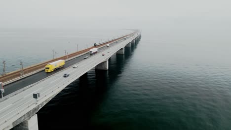 A-long-suspended-bridge-on-the-Baltic-Sea-with-cars,-trucks-and-a-train