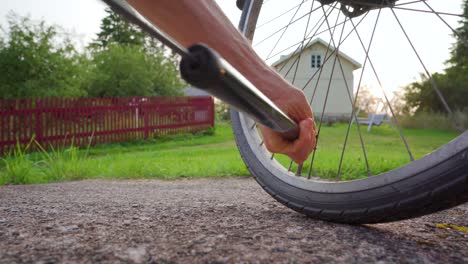 Hombre-Inflando-Un-Neumático-De-Bicicleta-En-Un-Entorno-Rural-En-Una-Soleada-Tarde-De-Verano