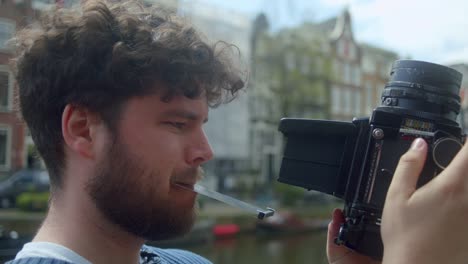Mann-Mit-Klassischer-Analogkamera-In-Amsterdam---Nahaufnahme