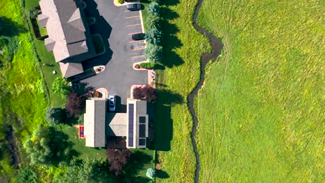 Meandering-river-to-newly-developed-subdivision-rapid-development,-drone-top-down-trucking-pan