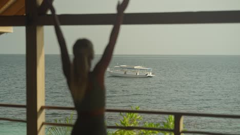 Frau-Praktiziert-Sonnengruß-Yoga-Pose-Mit-Fokus-Auf-Im-Wasser-Schwimmenden-Boot