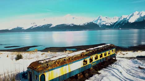 4K-Drone-Video-of-Abandoned-Alaska-Railroad-Train-Car-on-Seward,-Alaska-Beach-on-Snowy-Winter-Day