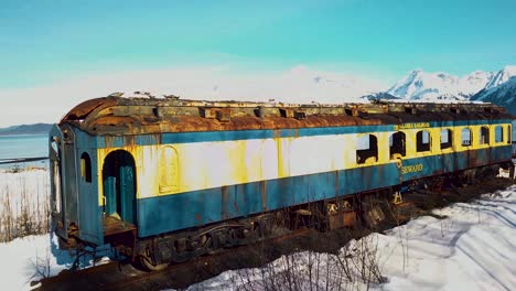 4K-Drone-Video-of-Abandoned-Alaska-Railroad-Train-Car-on-Seward,-Alaska-Beach-on-Snowy-Winter-Day
