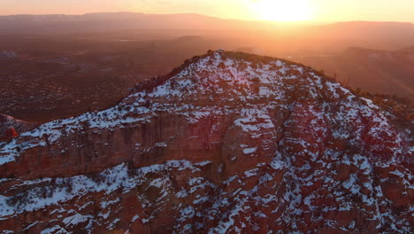 Mountain-peak-in-Arizona-covered-in-snow-in-warm-golden-sunset,-establishing-shot