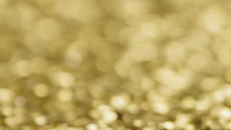 Gold-sequins-with-blurred-background,-establishing-background-shot