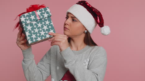 Verwirrte-Frau-Feiert-Weihnachten-Und-Schüttelt-Verpackte-Weihnachtsgeschenkbox-Lieferung,-Raten-Sie-Mal,-Was-Drin-Ist