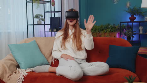 Junge-Frau-Nutzt-Zu-Hause-Eine-Virtual-Reality-Headset-Brille-Und-Genießt-Das-Videokonzept,-Indem-Sie-Hände-In-Der-Luft-Bewegt
