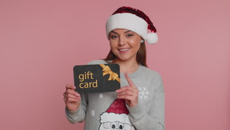 Woman-showing-pointing-on-gift-discount-certificate-Christmas-voucher-coupon-for-store-holidays-sale