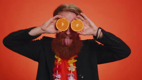 Handsome-tourist-man-putting-half-of-oranges-on-eyes,-vegetarian-lifestyle,-vitamins-for-health