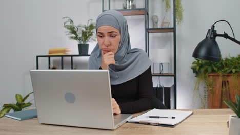 Mujer-De-Negocios-Musulmana-Pensando-En-Una-Importante-Decisión-De-Trabajo-De-Proyecto-Creativo-En-Una-Computadora-Portátil-En-La-Oficina