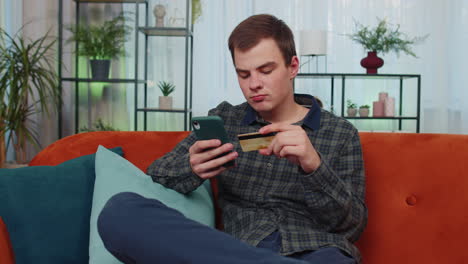 Teenager-Mann-Nutzt-Kreditkarte-Und-Smartphone,-überweist-Geld-Und-Kauft-Online-Ein