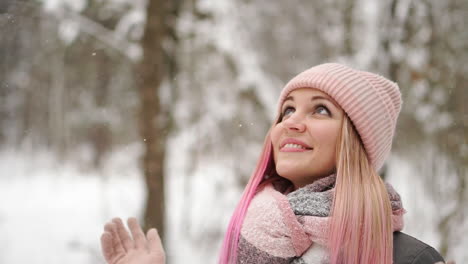 Outdoor-close-up-portrait-of-young-beautiful-happy-smiling-girl-wearing-white-knitted-beanie-hat,-scarf-and-gloves.-Model-posing-in-street.-Winter-holidays-concept.