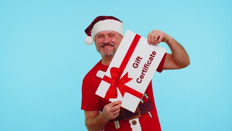 Mann-Im-Roten-T-Shirt-Mit-Weihnachtsmann-Weihnachtsmütze-überreicht-Dem-Gewinner-Eine-Karte,-Einen-Geschenkgutschein,-Einen-Gutschein