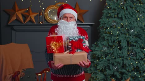 El-Abuelo-Mayor-Parodia-A-Papá-Noel-Presentando-Una-Caja-De-Regalo-De-Navidad,-Celebración-Navideña-En-Casa