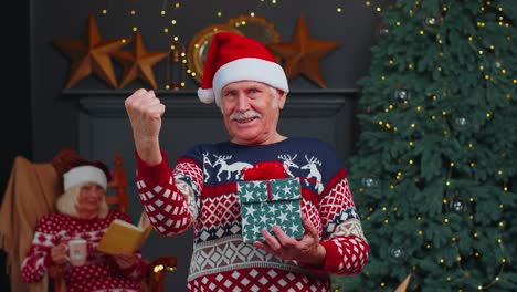 Reifer-Großvater-Im-Weihnachtspullover-Feiert-Erfolg,-Siegschrei-Und-Geste-Der-Siegerhand
