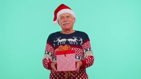 Senior-grandfather-man-wears-New-Year-sweater-presenting-Christmas-gift-box,-shopping-sale-holidays