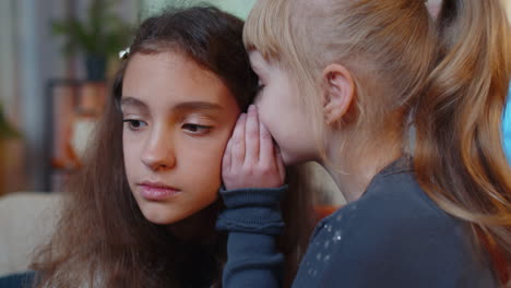 Teenage-child-whisper-news-rumors-in-ear-to-little-sister-kid-girl-share-secrets-gossip-having-fun