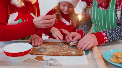Senior-family-grandparents-with-granddaughter-in-Santa-Claus-hats-preparing,-cooking-homemade-cookie