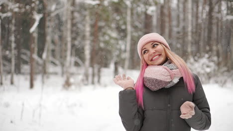 Frau-In-Jacke-Und-Hut-Blickt-In-Zeitlupe-Auf-Den-Schnee-Und-Fängt-Lächelnd-Schneeflocken-Ein