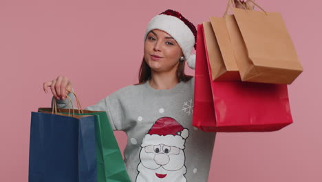 Fröhliche-Weihnachtsfrau-Zeigt-Einkaufstüten,-Wirbt-Für-Urlaubsrabatte-Und-Ist-Erstaunt-über-Niedrige-Preise