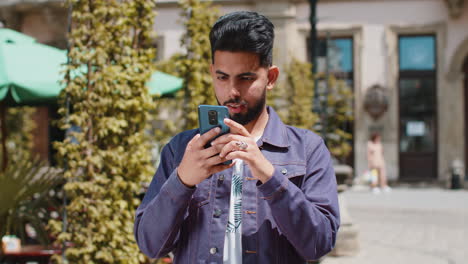 Junger-Indischer-Mann-Nutzt-Mobiles-Smartphone-Und-Feiert-Den-Gewinn-Guter-Nachrichten-Im-Freien-Auf-Der-Straße-Der-Stadt