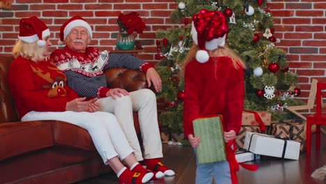 Enkelin-Schenkt-Den-Erstaunten,-Glücklichen-Großeltern-Zu-Hause-Weihnachtsgeschenkbox-Und-Feiert