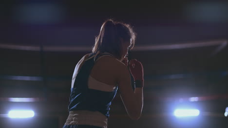 Female-boxer-training-in-dark-room-with-back-light-in-slow-motion.-steadicam-shot