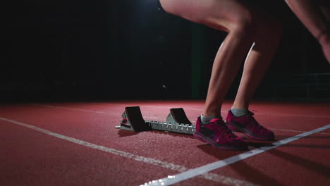 Female-hispanic-athlete-training-at-running-track-in-the-dark.-Slow-motion