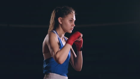 Beautiful-female-boxer-conducts-a-fight-with-shadow-while-exercising-in-the-gym.-Slow-motion.-steadicam-shot