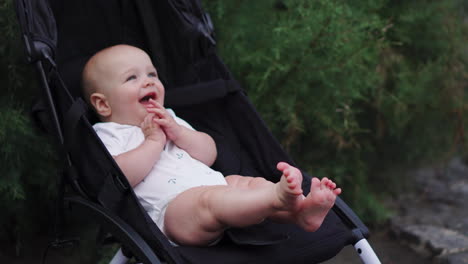 Ein-Lächelndes-Baby-Sitzt-In-Einem-Kinderwagen-Und-Lacht