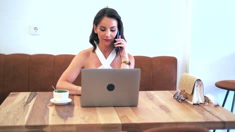 Geschäftsfrau,-Die-Während-Der-Arbeit-Auf-Dem-Smartphone-Spricht-Und-Auf-Dem-Laptop-Surft