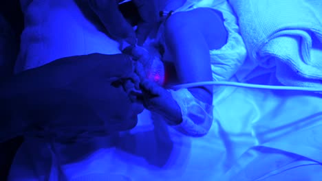 Parent-gently-touching-fragile-newborn-in-neonatal-incubator