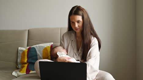 Madre-Con-Bebé-Usando-Laptop-En-El-Sofá