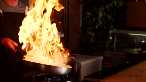 Kochen-Sie-Die-Zubereitung-Von-Speisen-In-Einer-Pfanne-Mit-Feuer