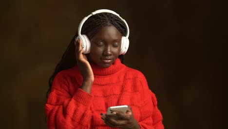 Smiling-African-American-teenager-in-headphones-with-smartphone