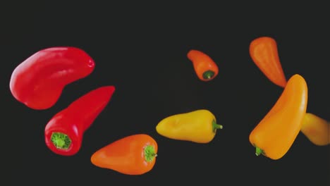 Colorful-peppers-flying-over-black-background