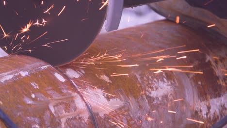 Crop-metal-worker-in-gloves-grinding-edge-of-metal-handiwork