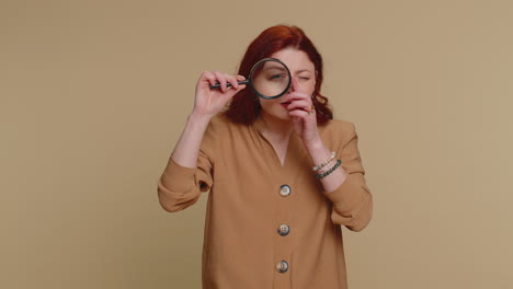 Investigator-researcher-woman-with-magnifying-glass-near-face,-looking-into-camera-with-big-zoom-eye