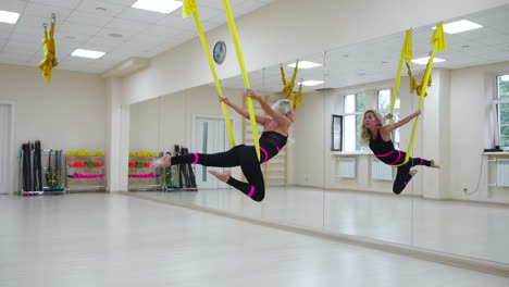 The-concept-of-sports-for-a-healthy-lifestyle.-The-girl-has-been-aerology-of-antigravity-relaxes-and-swings-on-the-canvas-in-a-white-room