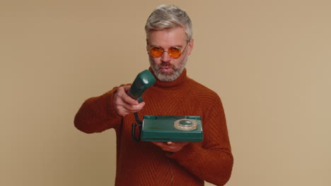 Middle-aged-old-man-talking-on-wired-vintage-old-fashioned-telephone-of-80s-advertising-call-me-back