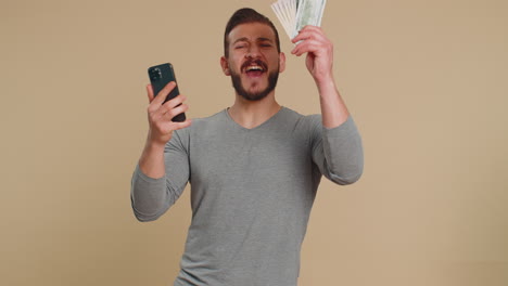 Lebanese-man-use-smartphone-rejoicing-win,-receiving-money-dollar-cash,-success-lottery-jackpot-luck